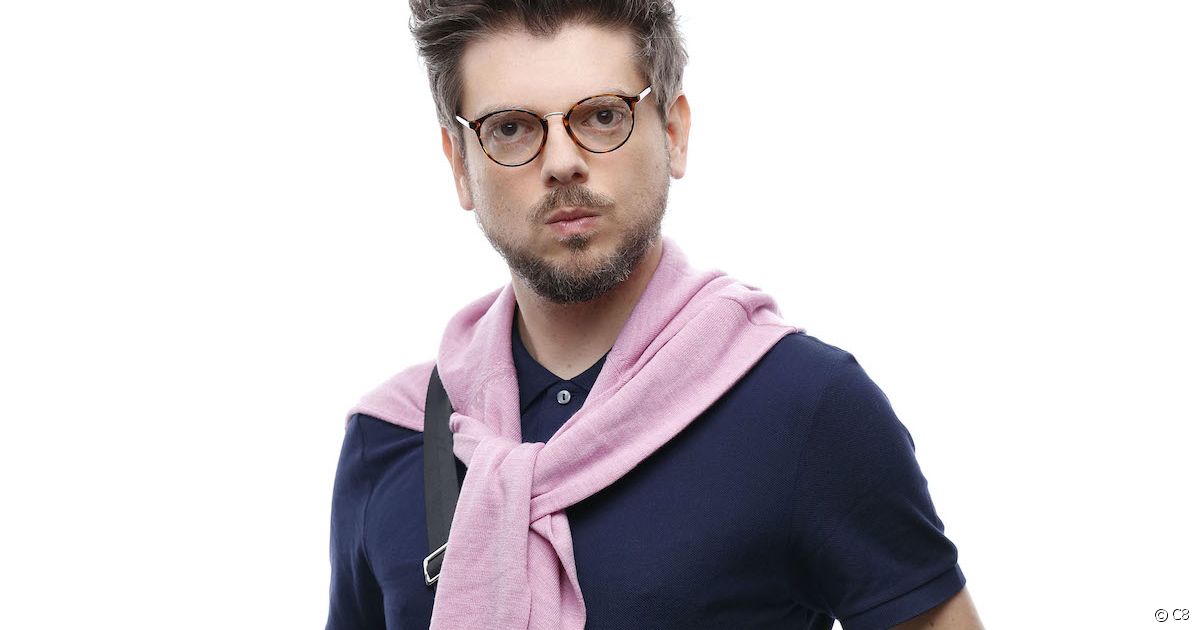 close up of a man with glasses with a pink sweater tied around his shoulders