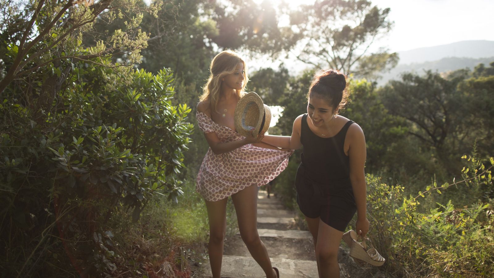 two girls laugh walking up steps