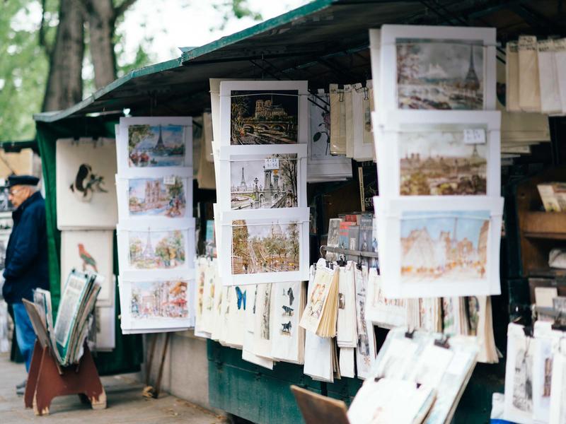 Outdoor market with art prints of Paris sites hanging up